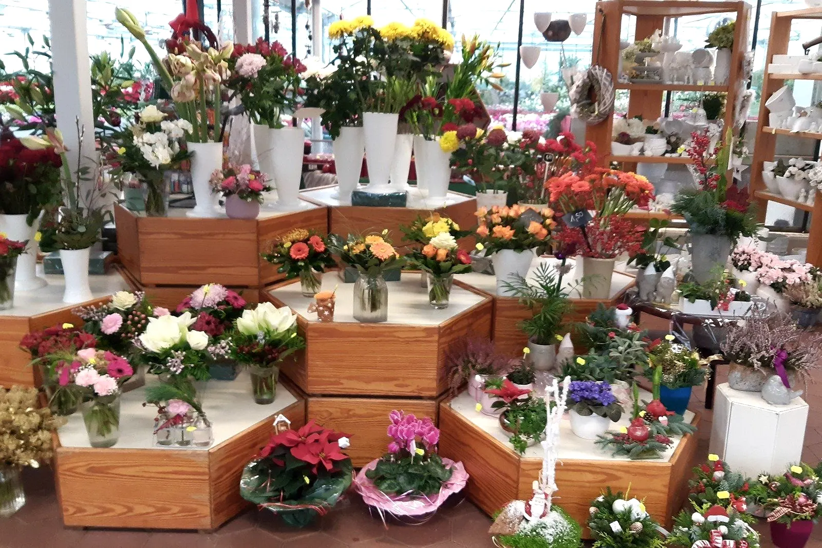 Blick in den Verkaufsraum von Blumen Herzog mit gebundenen Sträußen auf Holzpodesten